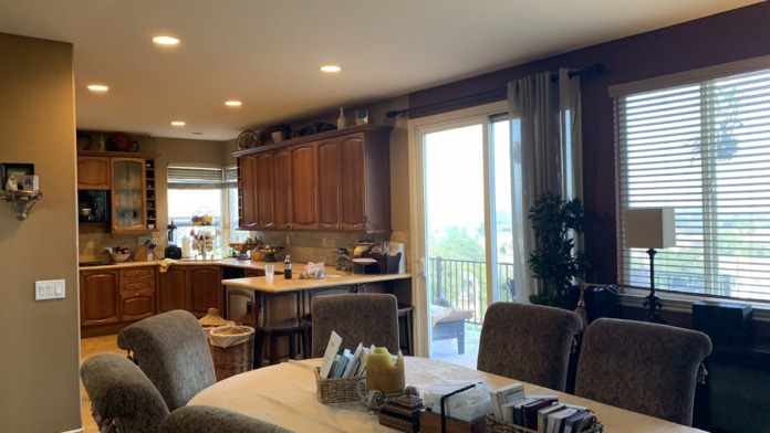 Interior kitchen and dining space with wood cabinetry, dining table, chairs, and large windows with views