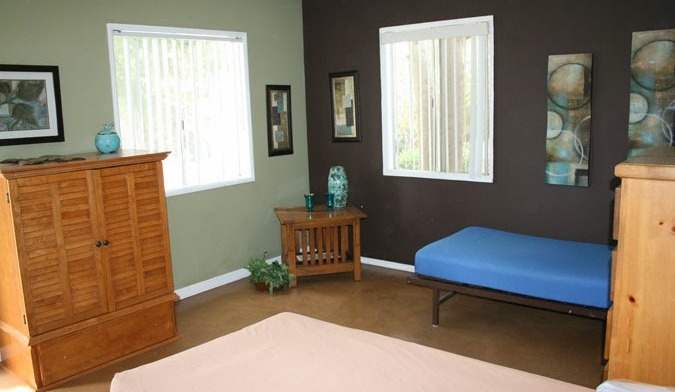 Interior bedroom space with multiple beds, natural lighting, and wooden furniture