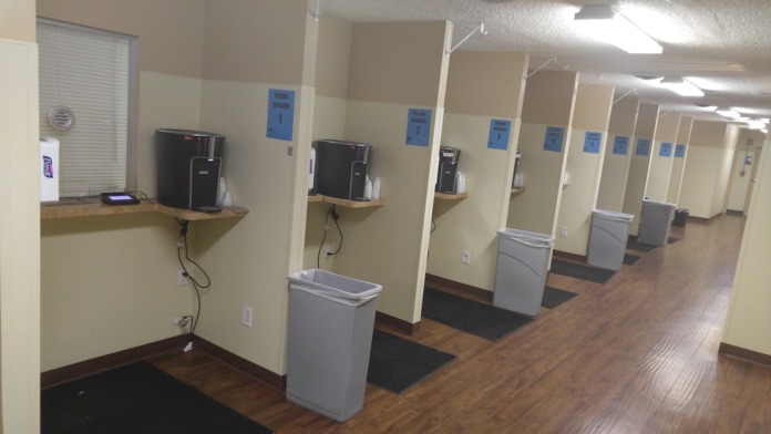 Interior office with desk, computer, chairs, yellow walls, and bulletin boards with posted information