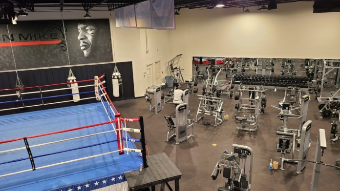 Interior fitness facility with boxing ring, heavy bags, and exercise equipment