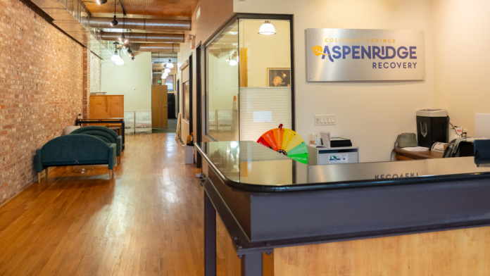 Interior reception area with brick walls, wooden flooring, glass office partition, and facility signage