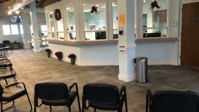 Interior reception counter with curved desk, multiple client chairs, and glass-walled office spaces with decorative accents