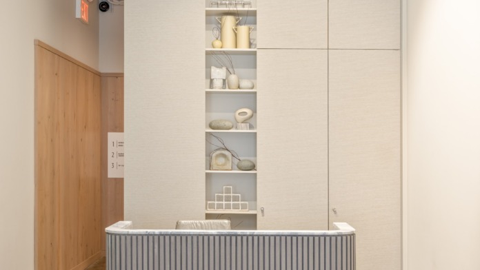 Interior reception area with modern desk counter, wall shelving, and organized office workspace