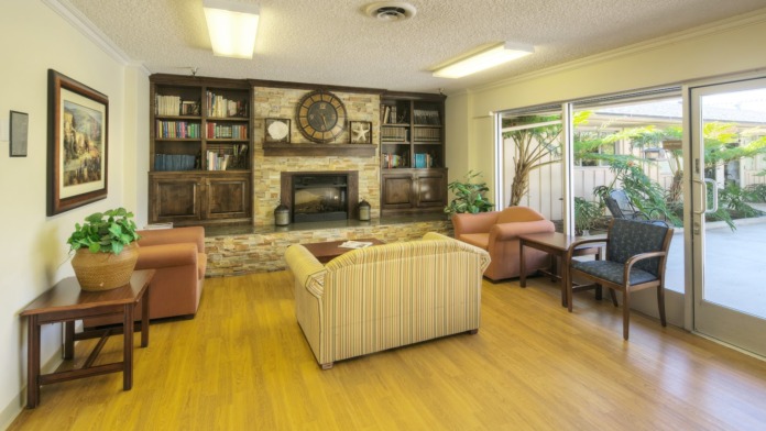 Interior activity room with tables decorated with tablecloths, natural daylight from doors, decorative elements and display screens