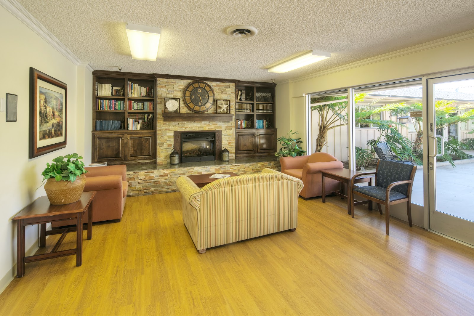 Interior activity room with tables decorated with tablecloths, natural daylight from doors, decorative elements and display screens