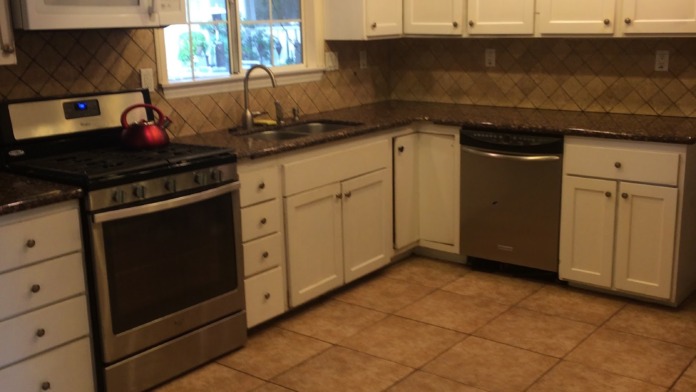Interior kitchen with white cabinetry, stainless steel appliances, granite countertops, tile flooring, and recessed lights