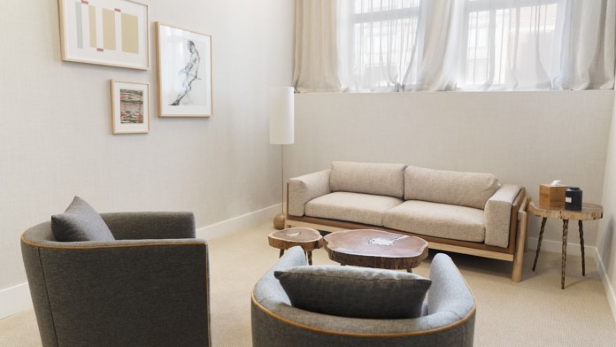 Interior lounge space with modern seating arrangements, coffee tables, and large windows providing natural light