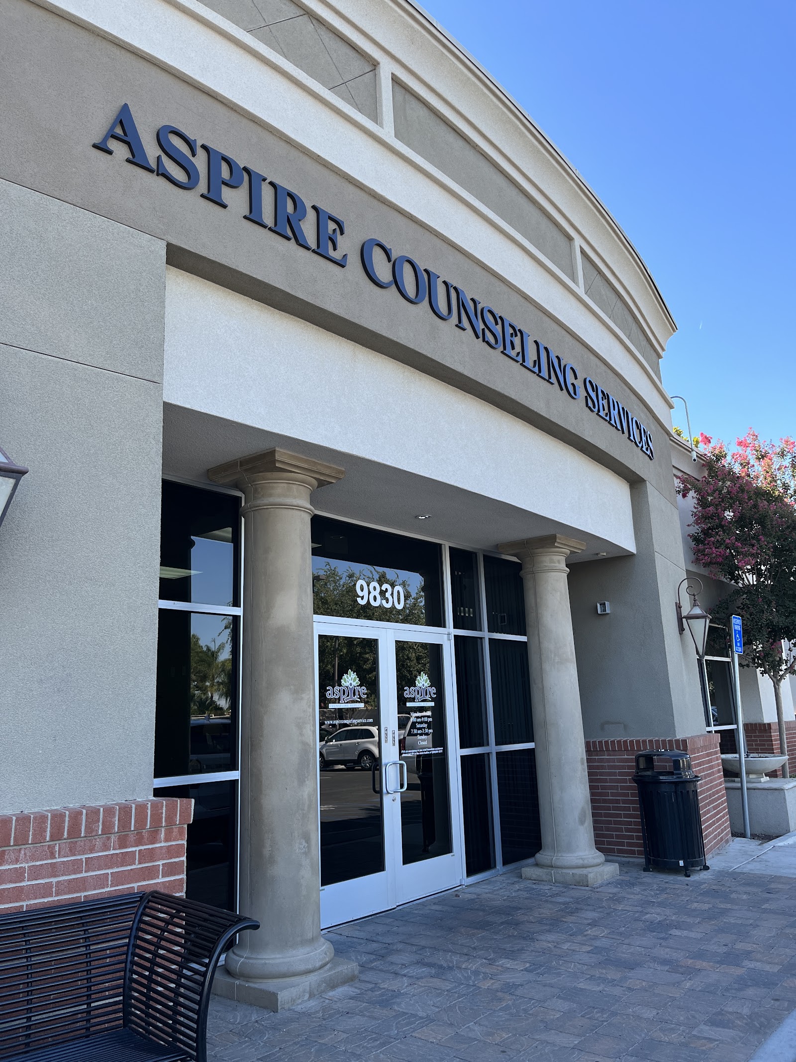 Exterior storefront entrance showing aspire Counseling Services name on facade with glass doors and columns