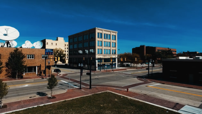 Exterior view of multi-story urban rehabilitation center building with modern blue facade, adjacent brick structures, and street intersection.