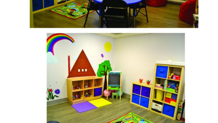 Interior playroom with colorful storage units, bean bag seating, educational toys, and play mats throughout space