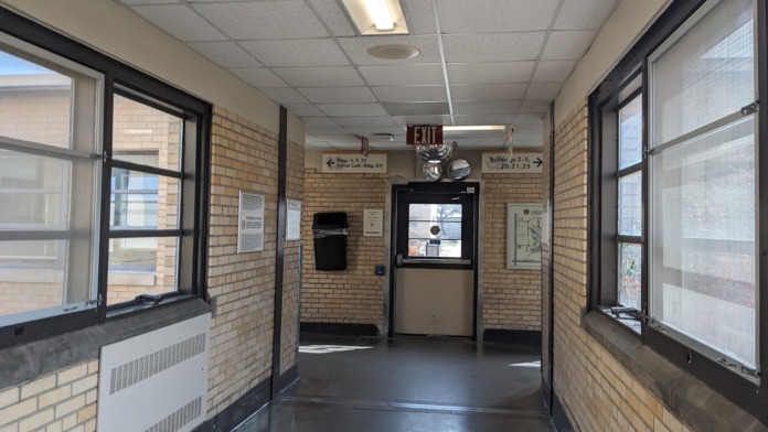 Interior entrance with brick walls, large windows, automatic door, and facility information displays