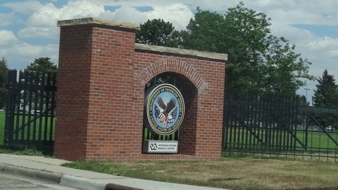 Exterior brick gateway with VA medical center eagle seal and wrought iron fencing