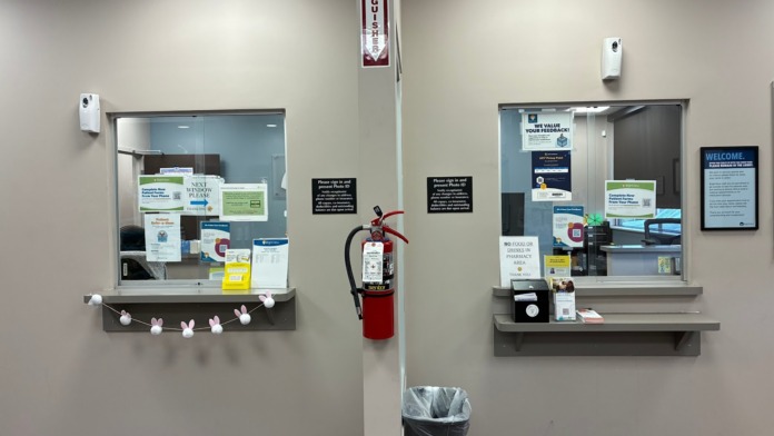 Interior entryway with informational boards, fire extinguisher, trash receptacle, ceiling lights, and wood flooring