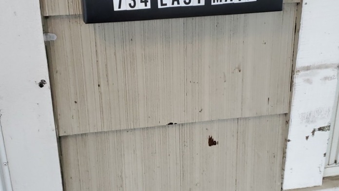 Exterior facility signage displaying Deerfield name and 734 East Main street address on wooden door