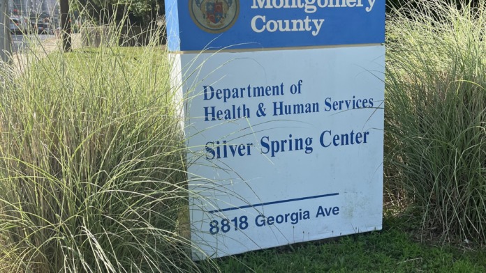 Exterior signage for Silver Spring Center with Montgomery County seal and address, surrounded by landscaping and trees.