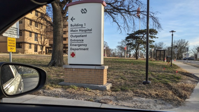 Exterior building directory sign showing hospital departments and emergency entrance locations