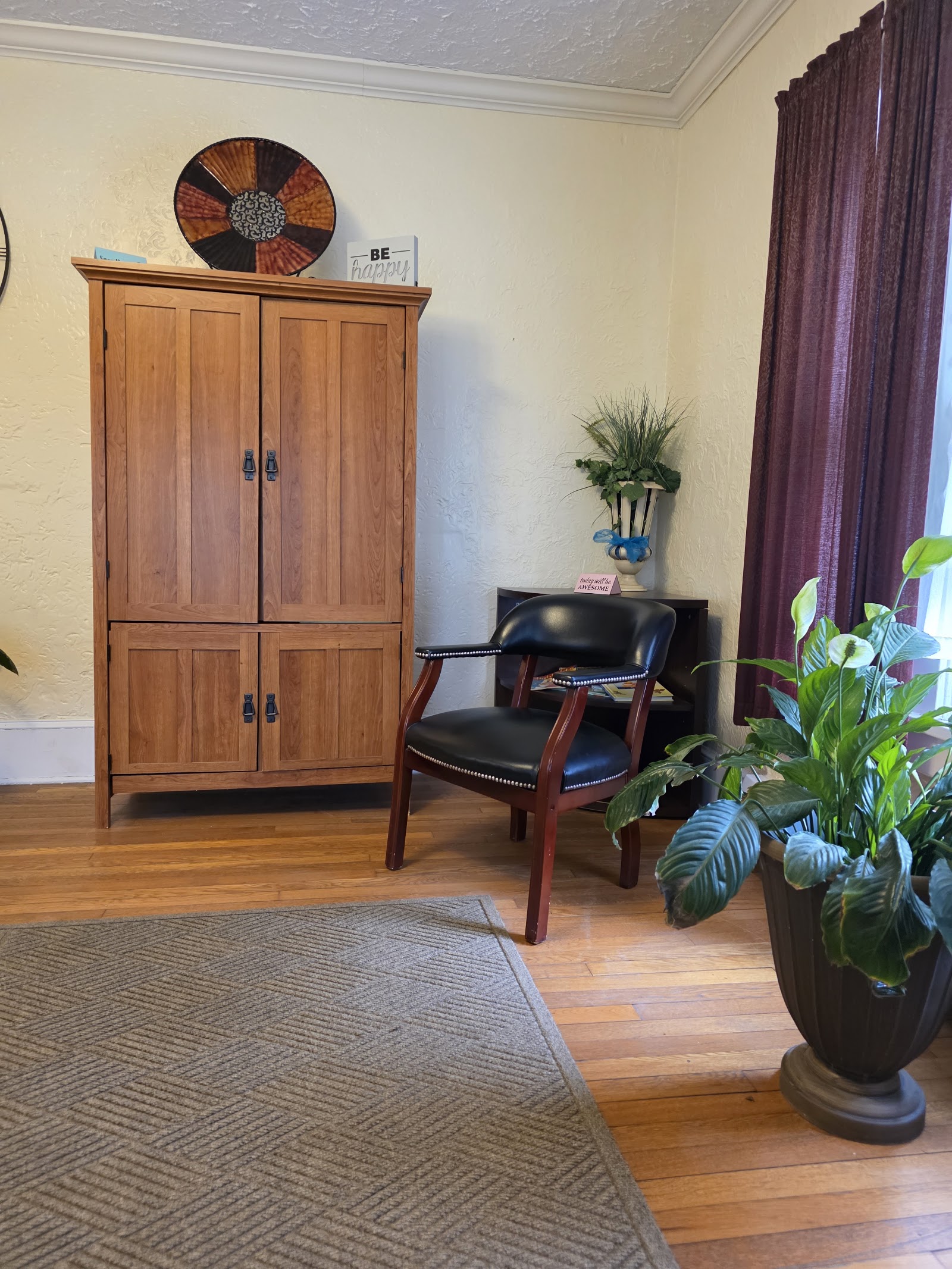 Interior lounge space with wooden storage cabinetry, leather seating, potted plants, and yellow walls