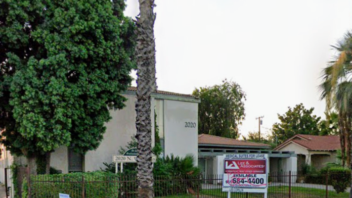 Exterior view of treatment facility building with ivy-covered walls, mature palm trees, and landscaped grounds