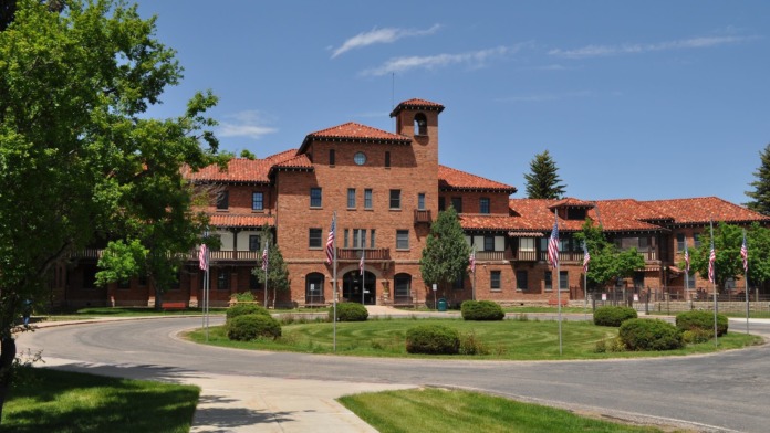 Exterior view of red brick Spanish Colonial Revival medical facility with tower and landscaped grounds