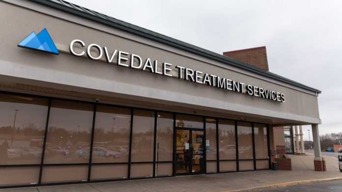 Exterior front facade showing Covedale Treatment Services storefront with blue logo, glass doors, windows, and concrete entrance