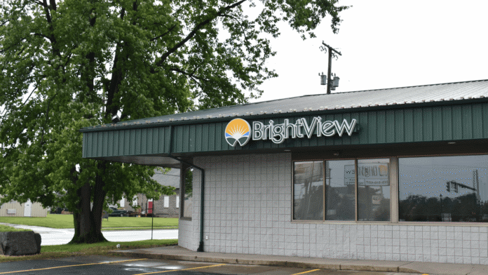 Exterior front view of BrightView treatment facility with signage, green metal awning, white brick facade, parking area, and landscaping