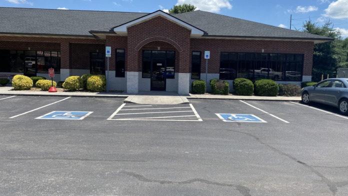 Exterior brick treatment facility with main covered entrance, accessible parking, and landscaped grounds