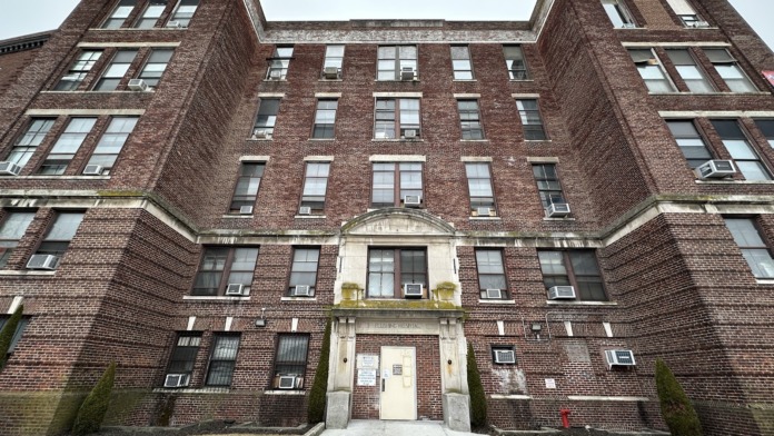 Exterior of multi-story brick medical building with symmetrical windows and central entrance pediment.