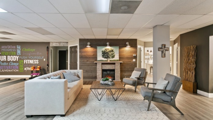 Interior reception area with fireplace, seating arrangement, wall art, motivational signage, and welcoming ambiance