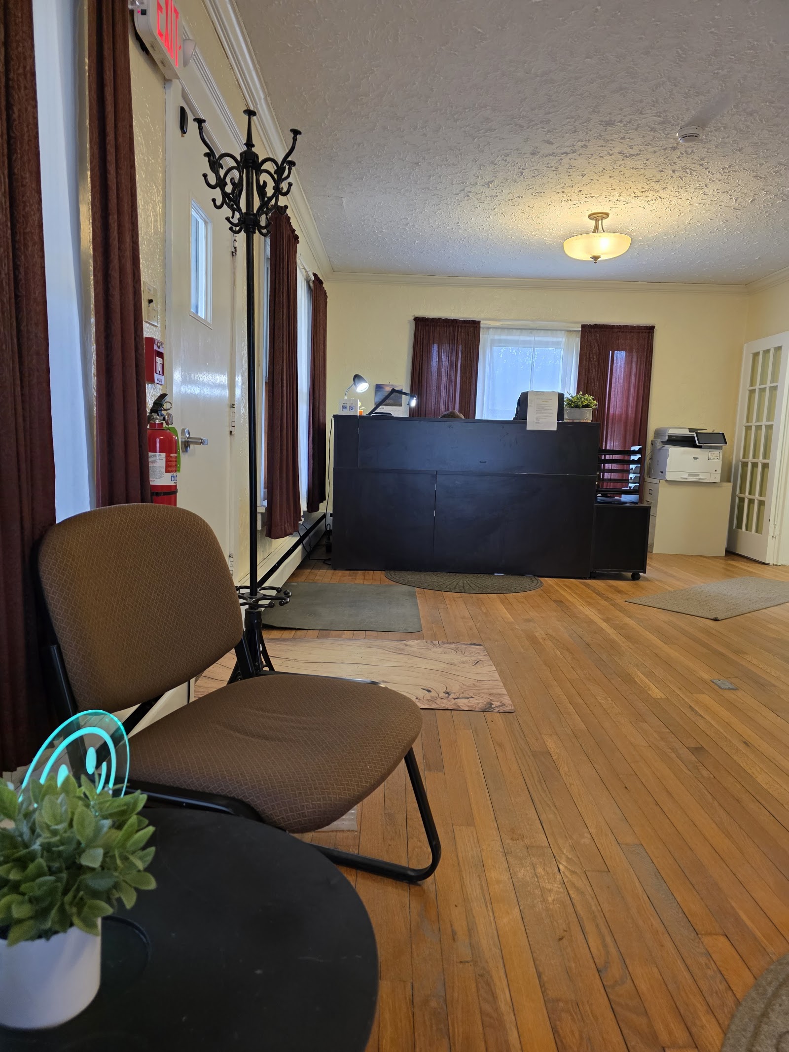 Interior main lobby with black reception desk, fireplace, stone accent wall, and multiple doorways
