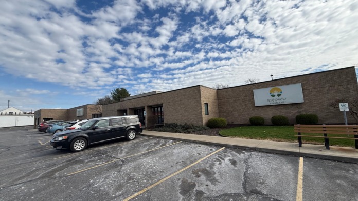 Wide angle exterior view showing parking lot, brick building facade, BrightView signage, and landscaping.