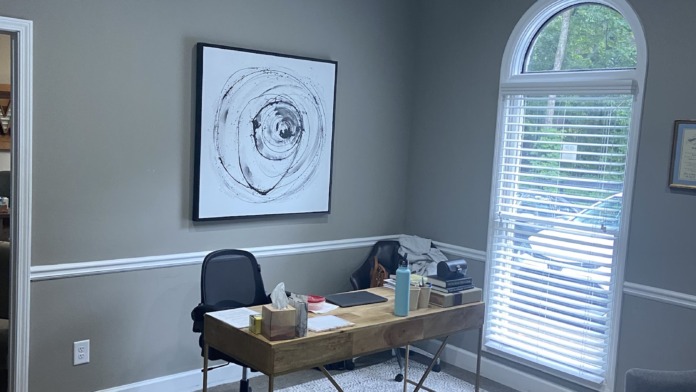 Interior office with desk, computer, executive chair, window with natural light, and professional workspace setup