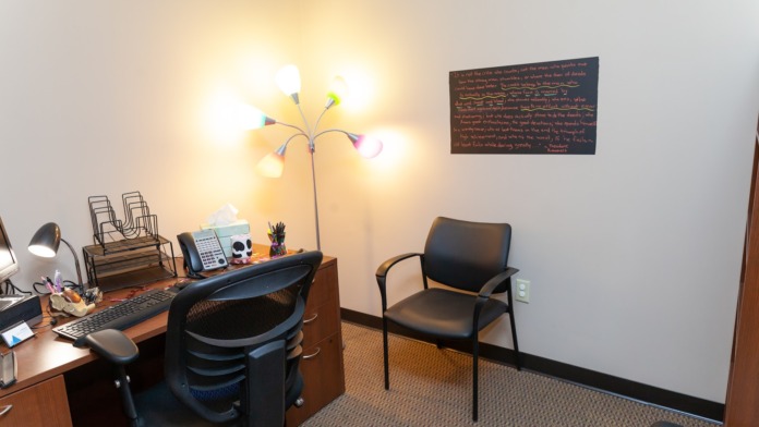 Interior office with desk, computer, office chair, lamp, and organized work area with neutral decor