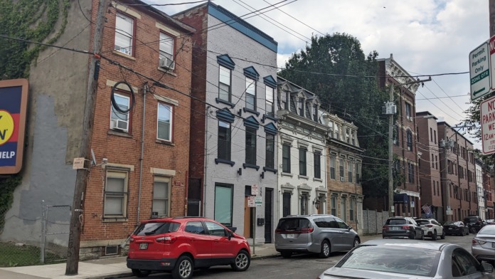Street view of historic urban buildings with Joseph House as part of neighborhood streetscape and parked vehicles