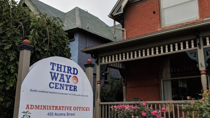 Exterior view of Third Way Center administrative offices showing red brick Victorian building with landscaped gardens and facility signage