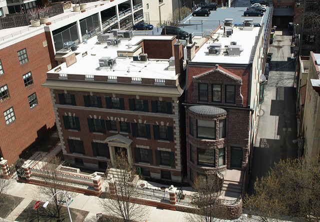 Exterior aerial perspective showing building roofline, adjacent structures, and urban surroundings