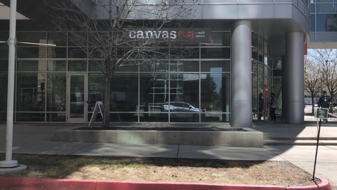 Exterior view of modern healthcare building entrance with glass doors, metal columns, and ground-level access