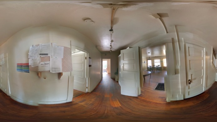 Interior hallway with white doors, wooden flooring, and architectural archways throughout the corridor