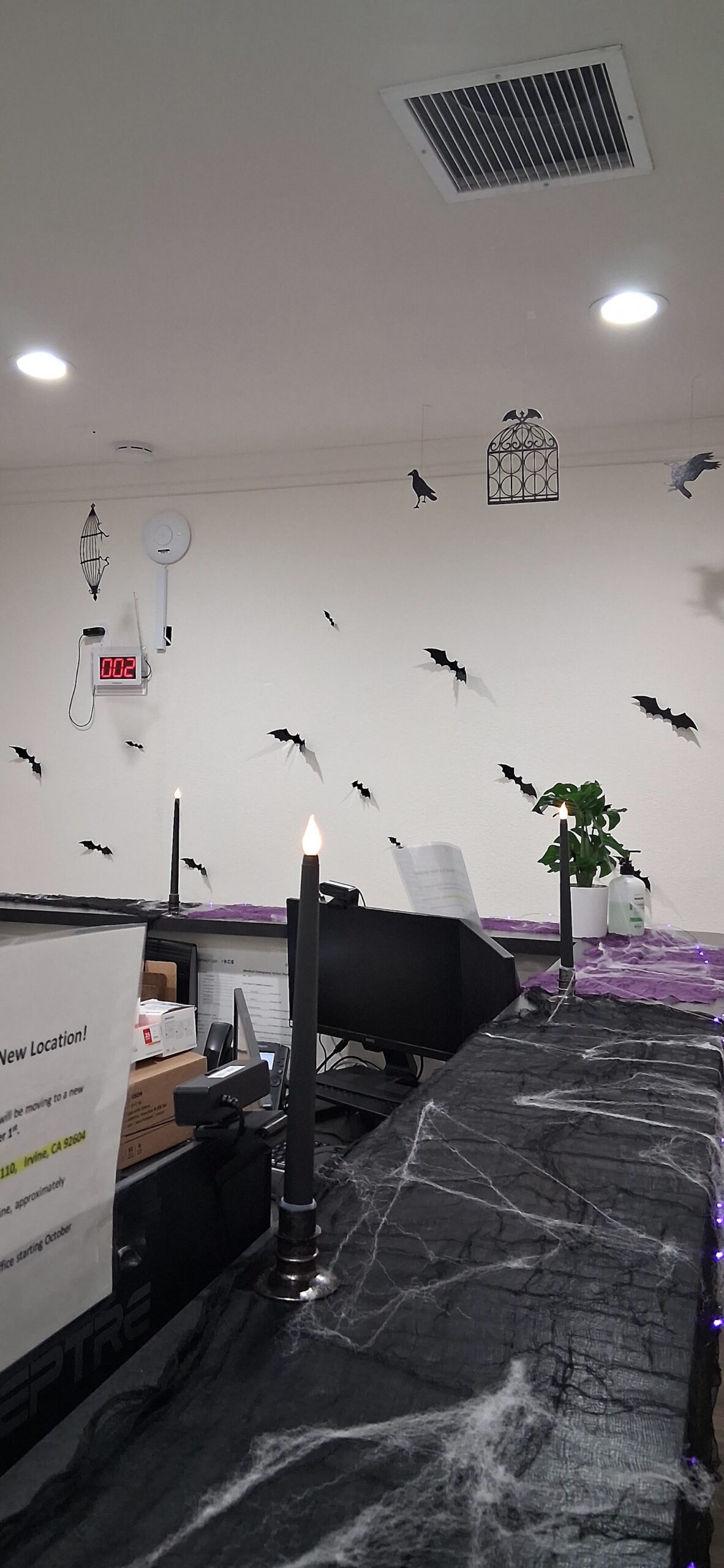 Interior common area with white ceiling, recessed lighting, Halloween decorations, and draped fabric elements throughout
