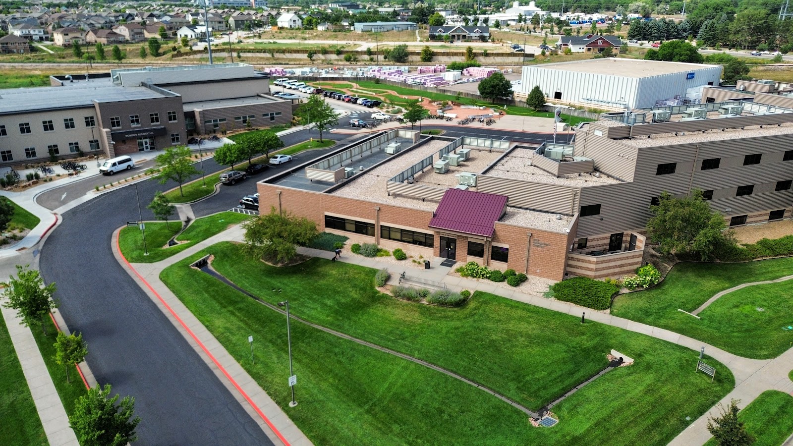 Exterior aerial view of treatment facility showing multiple buildings, parking areas, landscaped grounds, and surrounding community