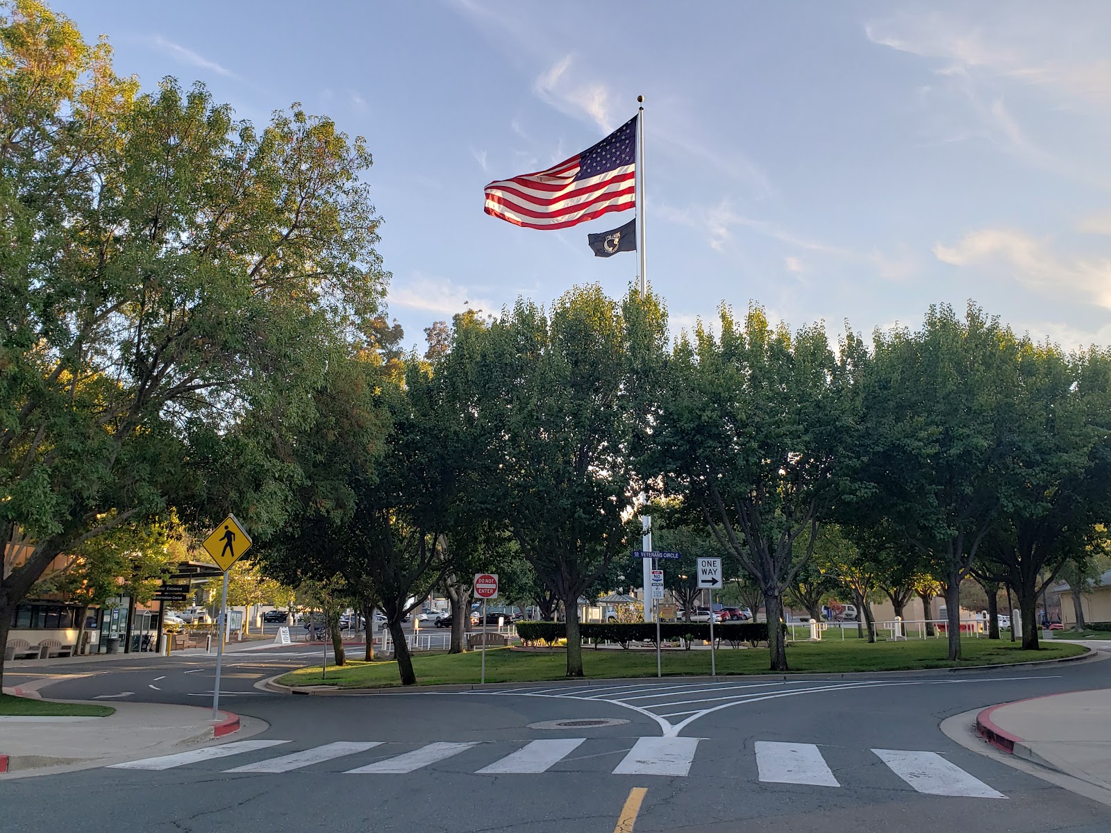 Outdoor view of VA facility entrance area with mature trees lining the grounds and facility structures