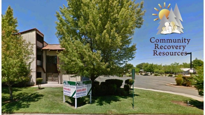 Exterior view of treatment facility building with mature trees, manicured lawn, and Community Recovery Resources signage