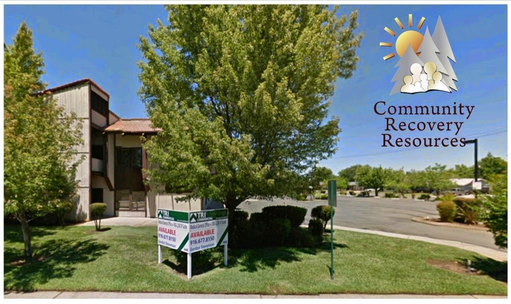 Exterior view of treatment facility building with mature trees, manicured lawn, and Community Recovery Resources signage