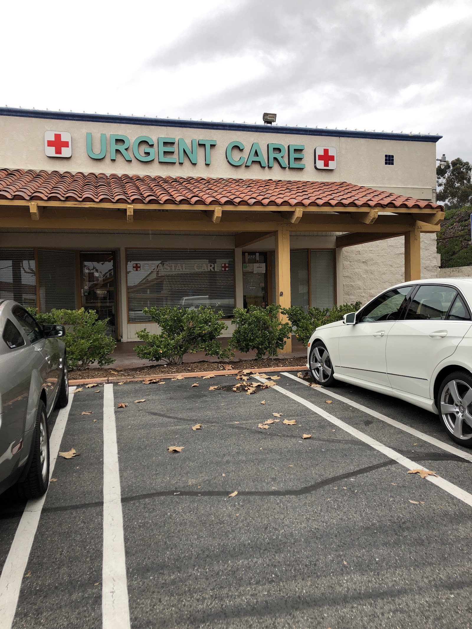 Exterior view of treatment center building facade with parked vehicles and landscaped vegetation