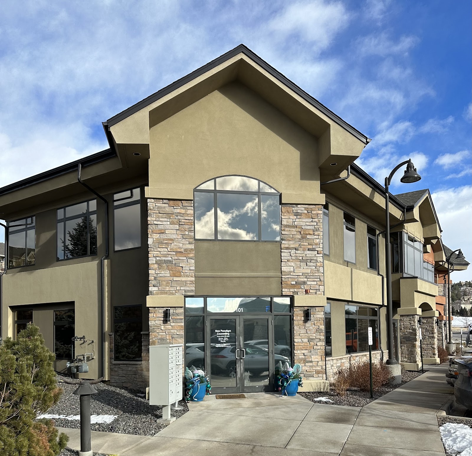 Exterior side view of treatment facility showing architectural details, large windows, and landscaped grounds with snow
