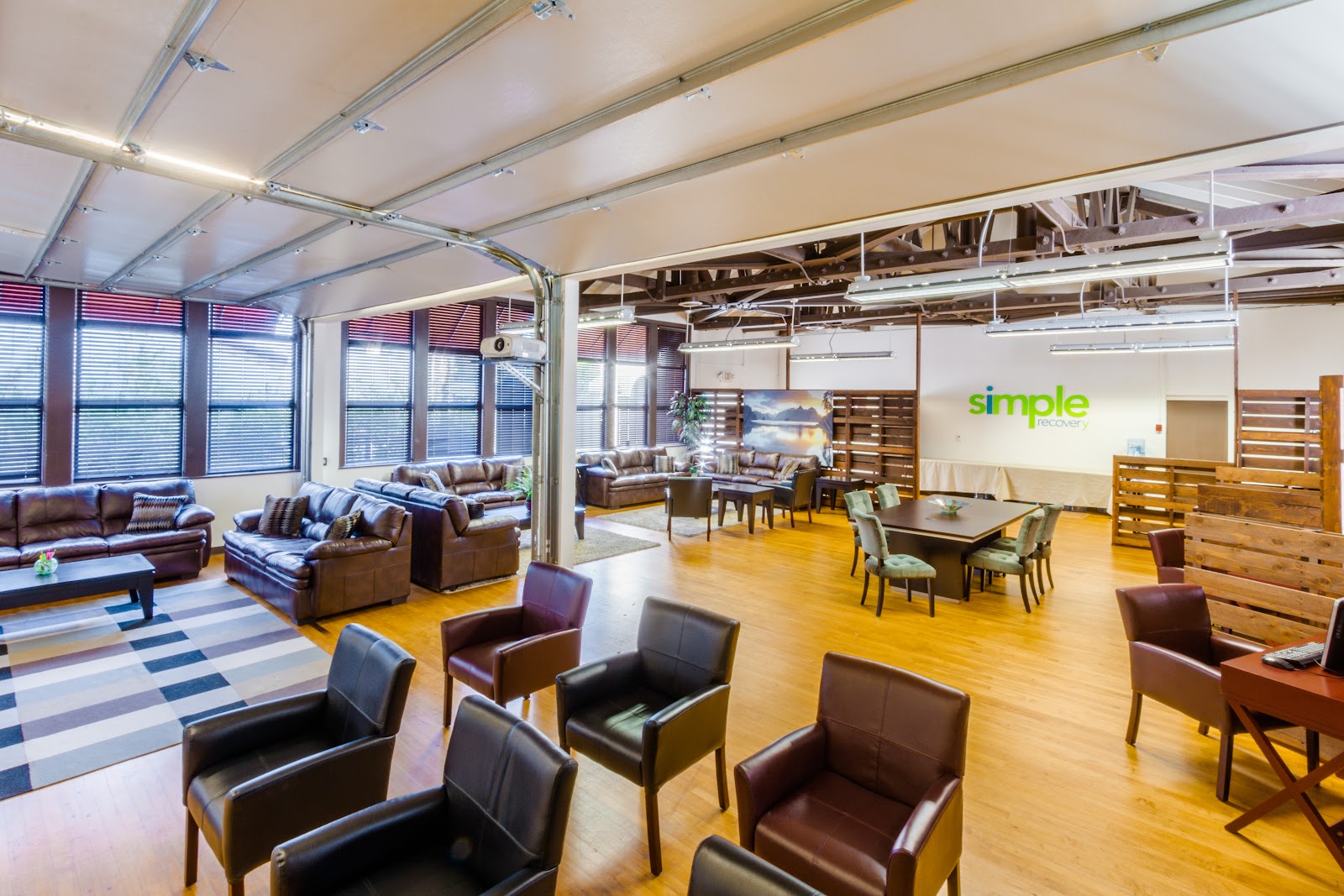 Interior lobby space with leather seating, wooden dividers, modern furnishings, and facility branding