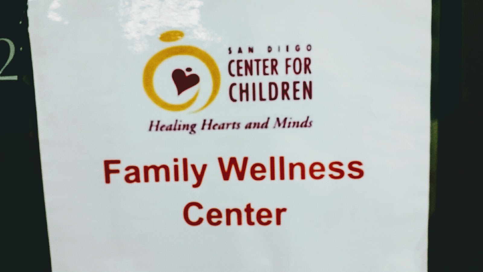Close-up view of San Diego Center for Children logo with heart symbol and Family Wellness Center text on light background