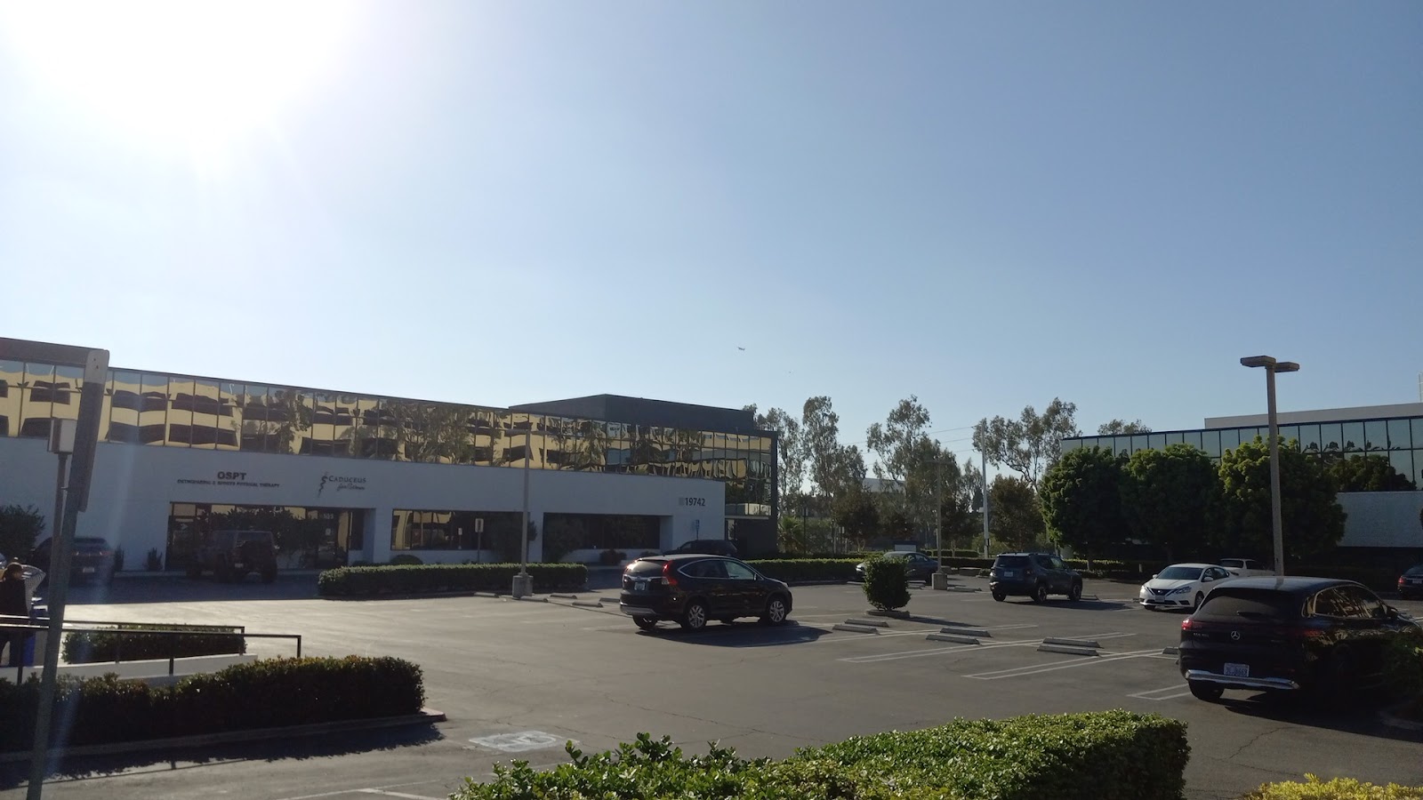 Exterior view of multi-building treatment center complex with parking lot, vehicles, and landscaping