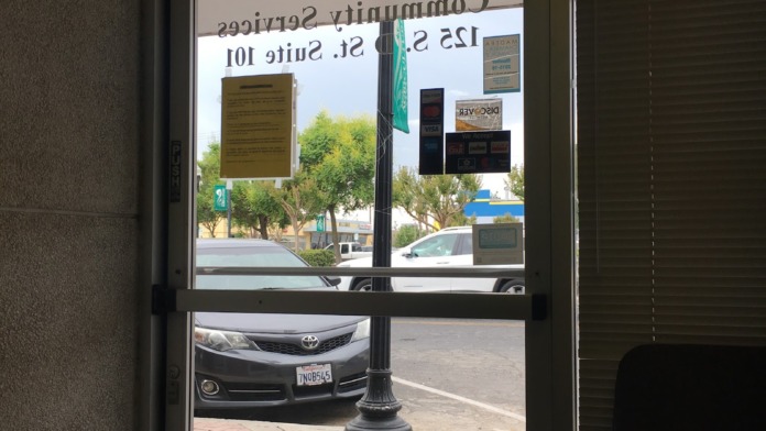 Exterior entrance door with Kings View Community Services signage, address, and payment logos displayed on glass