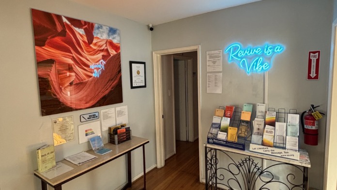 Interior reception area with neon signage, informational displays, and branded materials on walls and desk