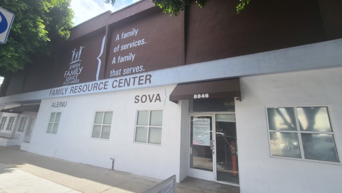 Exterior view of Family Resource Center building with white lower facade, brown upper section, main entrance door, and facility signage